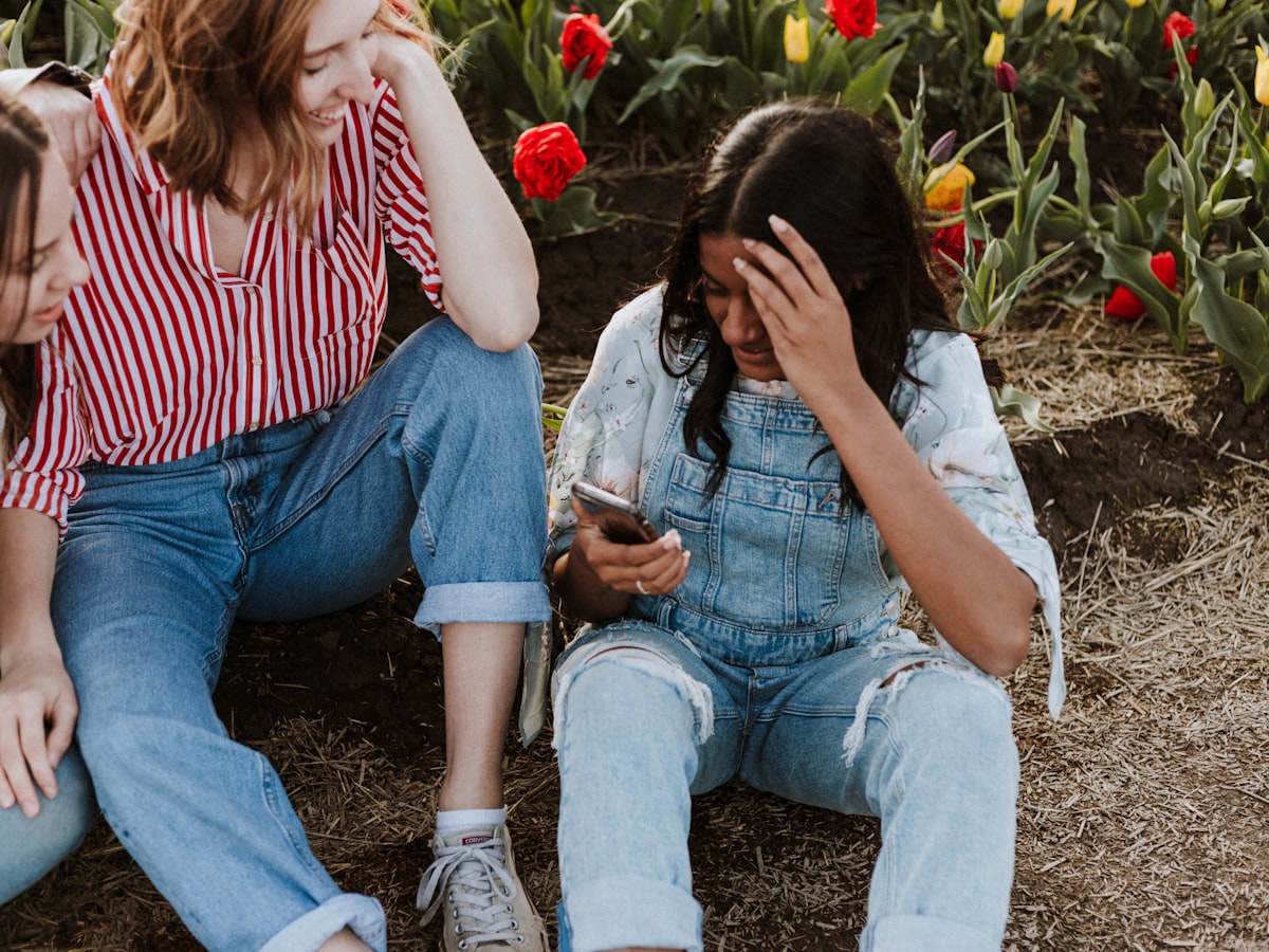 Friends looking at a phone in a garden